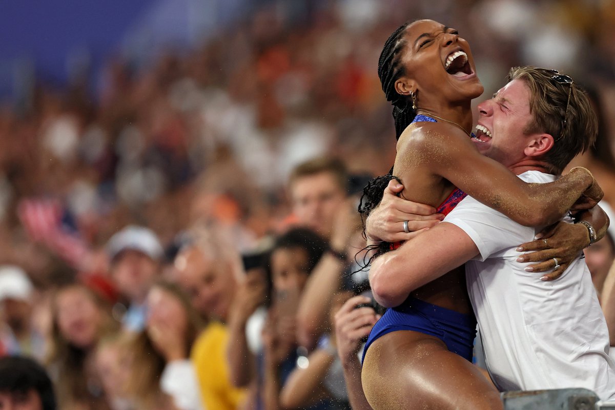 TheWrap's tweet photo. USA long jumper Tara Davis-Woodhall is congratulated by her husband, Paralympic medalist Hunter Woodhall, after winning GOLD in the women's long jump final at the #Olympics. 😍🏅 https://t.co/9lSk5qFcJd