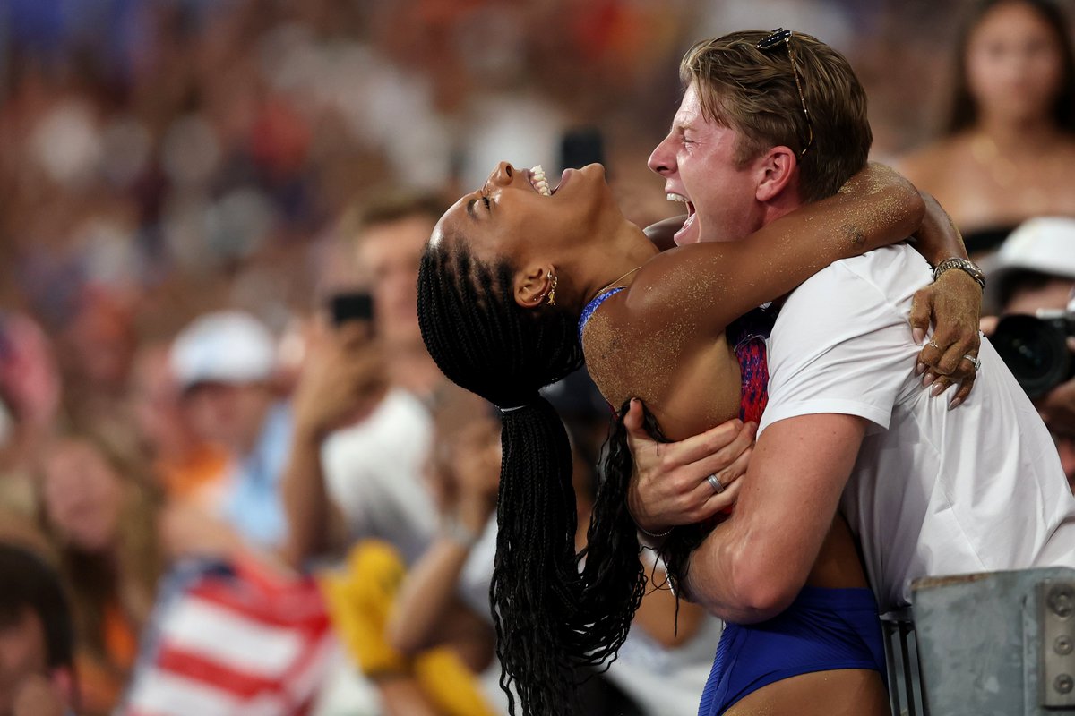 TheWrap's tweet photo. USA long jumper Tara Davis-Woodhall is congratulated by her husband, Paralympic medalist Hunter Woodhall, after winning GOLD in the women's long jump final at the #Olympics. 😍🏅 https://t.co/9lSk5qFcJd