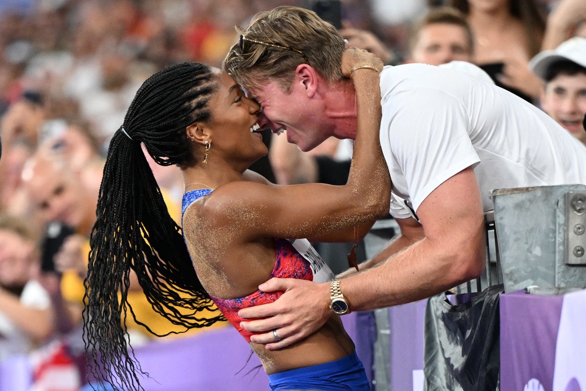 TheWrap's tweet photo. USA long jumper Tara Davis-Woodhall is congratulated by her husband, Paralympic medalist Hunter Woodhall, after winning GOLD in the women's long jump final at the #Olympics. 😍🏅 https://t.co/9lSk5qFcJd