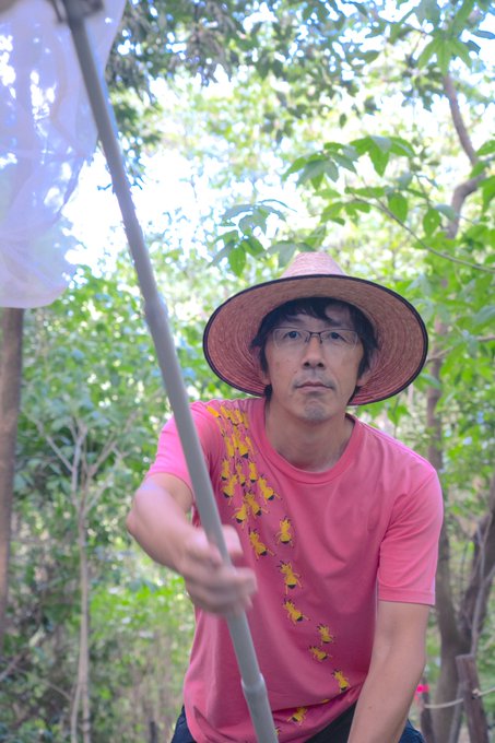 ピンク色のTシャツを着て、虫捕り網を持った村上貴弘先生