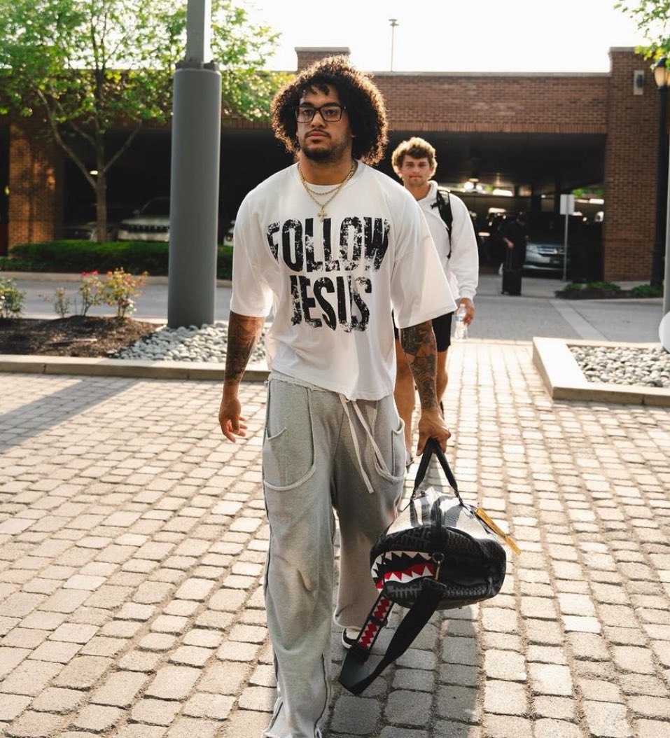 Over 20 Ohio State football players were seen wearing shirts with messages about Jesus as the team arrived at a hotel for fall camp. The shirts featured slogans such as "Follow Jesus," "Jesus Won," "Jesus Saves," "God Got Me," and "Just Here To Give God Glory," among others.