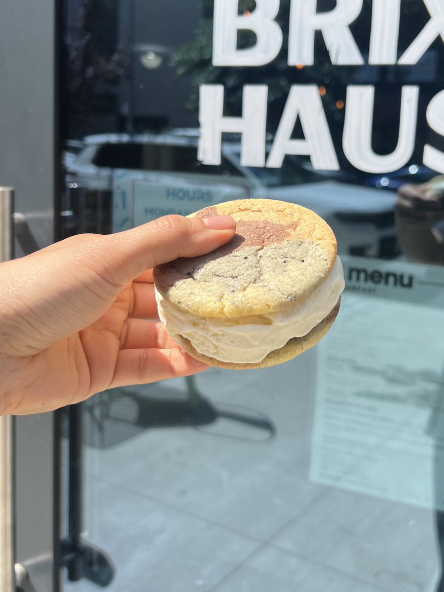 a scoop of sweetened condensed milk ice cream nestled between two black sesame, chocolate, vanilla, and Thai tea flavored cookies……………….