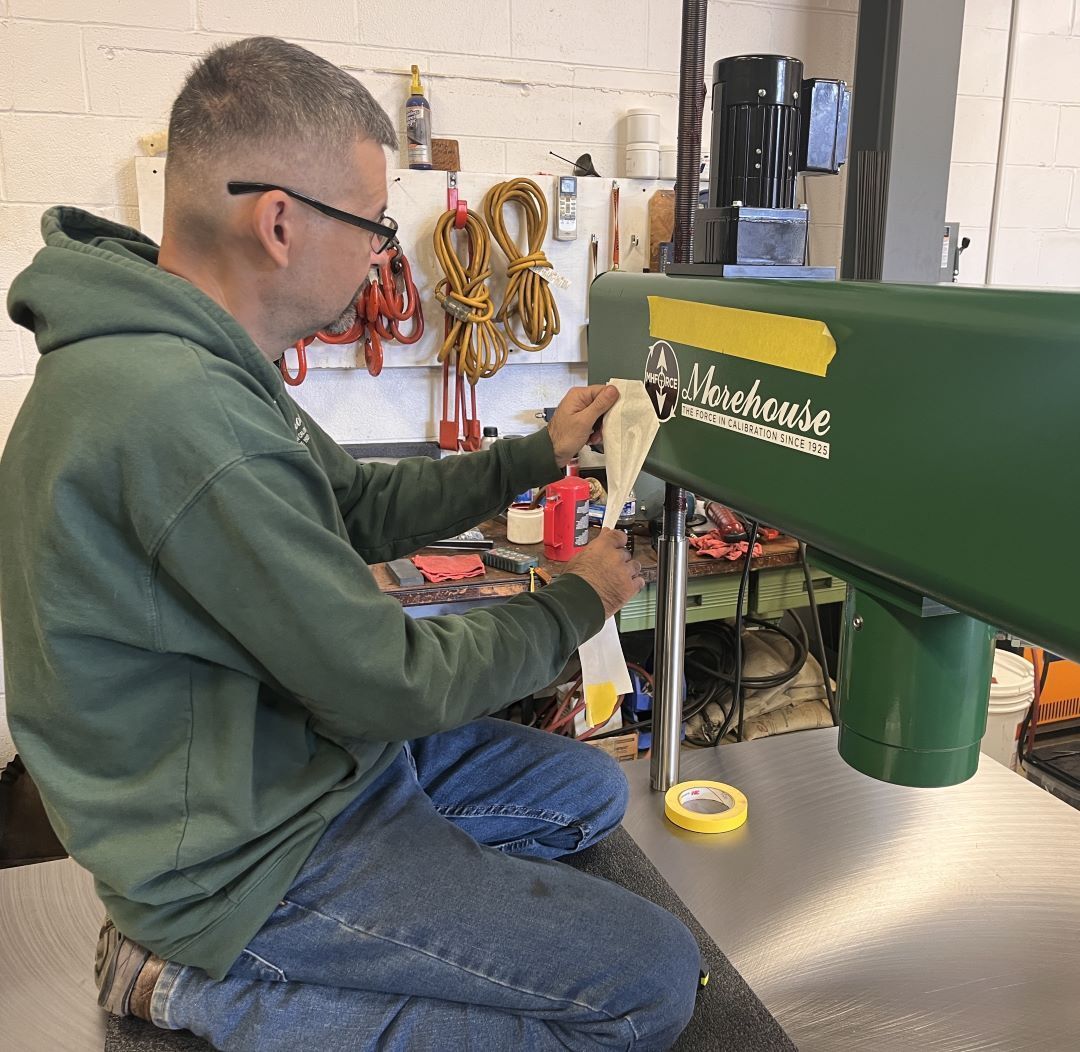 mhforce1's tweet photo. At Morehouse Instrument Company, a machine isn't complete until it bears our name. Production technician Norman Claybaugh carefully applies the final touch to the Morehouse Universal Scale Calibrator.  More on the scale calibrator is found here: https://t.co/nUaXduzWvy. https://t.co/0gA6j5Y2Pa
