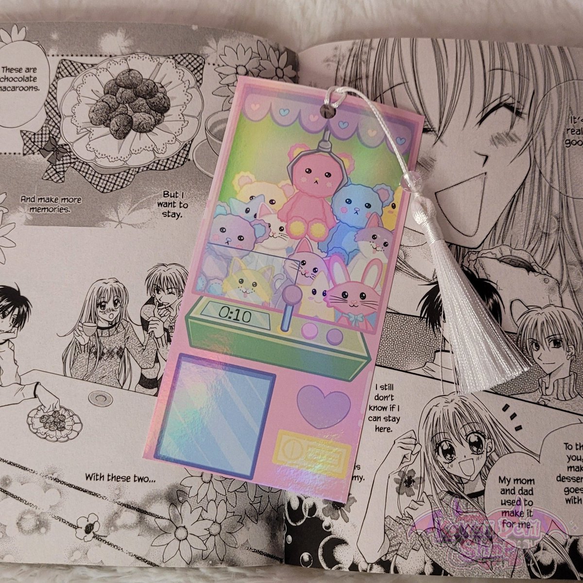 KawaiiDevilShop's tweet photo. Kawaii claw machine bookmark 🧸
✅️ Double sided
✅️ Holographic laminate 
✅️ White tassel

Available in my shop now 🥰

What book or manga are you paring this bookmark with? https://t.co/QESfQD1Nae