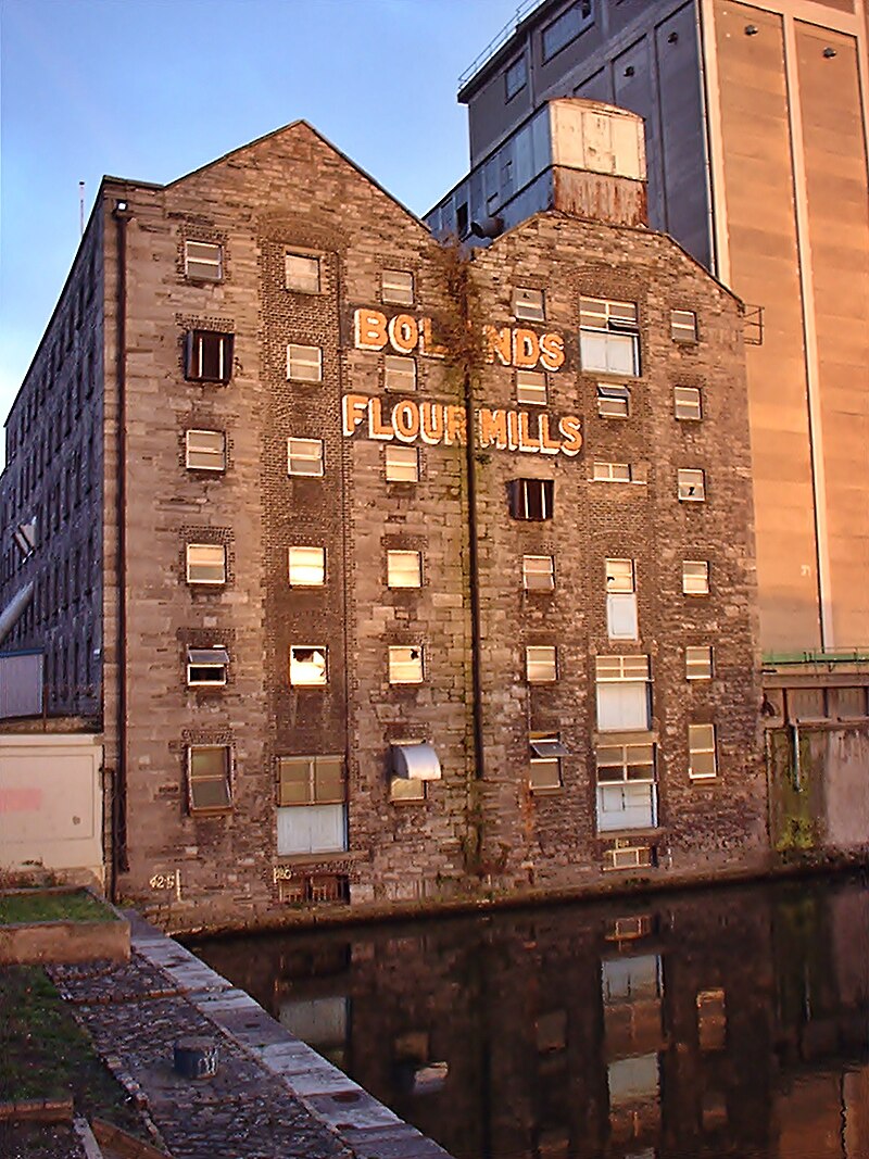 March 1984. Design Tower, Grand Canal Quay, Dublin. U2 photographed at the top of the eight storey former warehouse (see arrow) with Bolands Flour Mills in the background. This was part of an MTV feature taken to celebrate St Patricks Day: youtu.be/HiXTaqc_vTs?si