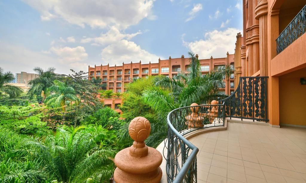 TheMutaD's tweet photo. Peanut 🥜 Colour, the Serena Kampala Hotel and Kampala's copycat culture 

In 2004, when Uganda still worked somewhat effectively, the Nile Hotel International Limited, a wholly GOU owned parastatal, gave a 30-year concession to the AKDN trading as Tourism Promotion Services to establish the Kampala Serena Hotel. The intention was to invest $18m to turn the 85-room facility into a 146 key 5 ⭐ hotel and refurbish the Kampala International Conference Center that had been built by the Idi Amin administration and hosted the 1976 Organisation of African Unity (OAU) Heads of State and Government Meeting.

Eventually, the facility's revamp took some $30.5 million and the rooms ended up being 152, instead. (There was an $8 million revamp in 2016, to celebrate 10 years of the concession, that increased room capacity to 188 rooms when 36 more keys were added).

Jon Cavanagh, undergirded a team from Symbion, the interesting architectural outfit, that was to later wrest almost all business from Ssentoogo & Partners and has had a disproportionate influence, together with FBW, on Kampala's office and institutional built environment.

His team, chose the peanut colour. It wasn't popular and wasn't that commonly asked for according to a friend, who at the time, worked out of Sadolin, the  plant that made the product.

On 12th November 2006, or thereabout, the Aga Khan and M7 opened the facility. The Symbion guys and their team had actually outdone themselves in creating one of the more enchanting (even 20 years later) hotels, in East Africa.

The guys who were making the paint were so overwhelmed by orders over the next 2-3 years that they had to study why there was such a sudden spike in demand for a paint that was at best a filler on the paint catalogue.

The answer, as my friend recounts, was the Kampala Serena Hotel. All of a sudden, every mugaga (rich man) wanted their new apartment block or house for one of their wives painted in coconut. They would tell their builders and painters to use 'that colour like on the Serena'!

Now older and wiser, the fellow who used to work part time at the paint plant while at university, has his own way of looking at that phenomenon.

He says unique for a peacetime city in Africa, Kampala is the only place where money doesn't chase ideas or rather the class with access to capital or whatever little money is left after the '86ers and their cronies have skimmed off the cream, doesn't like nor associate nor consider ideas from what he called the poverty stricken thinking and imaginative classes.

Every other city has a vibe of a thinking class that actually has some spare change. To think/ideate in Uganda, is akin to day-dreaming or committing suicide. 

He postulated that this made many people in this city, to conform, hence the French Cut houses, that served little utility in the mid-90s to late 90s. The pitched, clay-roofs, still little utility, of the early to mid 2000s, the garish bathroom tiles on patios and shades and walls of the quickly forgotten 2006-2010 era, and now, the strip malls that everyone with money is building in Kyanja+Kisaasi+Kabalagala or any suburb worth its name.

He had no kind words for the 320 plus "arcades" or "malls" in downtown Kampala that are barely distinguishable from each other in their architectural ugliness, and now, have mostly lost utility, less than 10 years after most were built, as the mass exodus to the strip malls in the suburbs continues unabated.

He was smoking and drinking whisky at the same time and muttering curses with the word peanut interspersed, when I left him.

Gave our whole informal discussion group at Ozahi and X-Arena (one of the better curated hanging places) in Ntinda, something to ponder.

How do we make ideas and capital get to each other? Are our ideas and ideation so off they can't attract capital? Is this unique to Kampala, alone?

Serena gave us peanut as a color and not food as some knew it, are Strip Malls the new peanut colour?