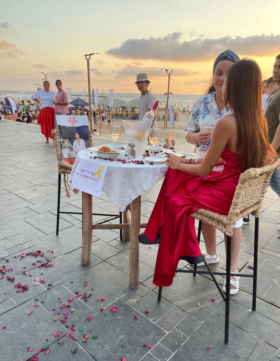JeremBenhaim's tweet photo. Ce soir, débutera Tou Be’Av, la Saint-Valentin juive.

Ziv Abud est l’une des survivantes du massacre du 7 octobre. Son fiancé, Eliya Cohen, est toujours retenu en otage à #Gaza dans des conditions inhumaines.

Symboliquement, elle a organisé un dîner romantique sur la plage de Tel Aviv avec la photo de son fiancé sur la chaise où il aurait dû être assis face à elle.

Très touchés, beaucoup de personnes sont venues serrer Ziv dans leurs bras pour lui exprimer tout leur soutien. ❤️

J’ai vraiment les larmes aux yeux en voyant ces images émouvantes…

Du fond du cœur, je fais le vœu pour qu'Eliya soit libéré le plus vite possible afin qu’il puisse rentrer à la maison retrouver sa famille et Ziv.

#BringThemHomeNow🎗️