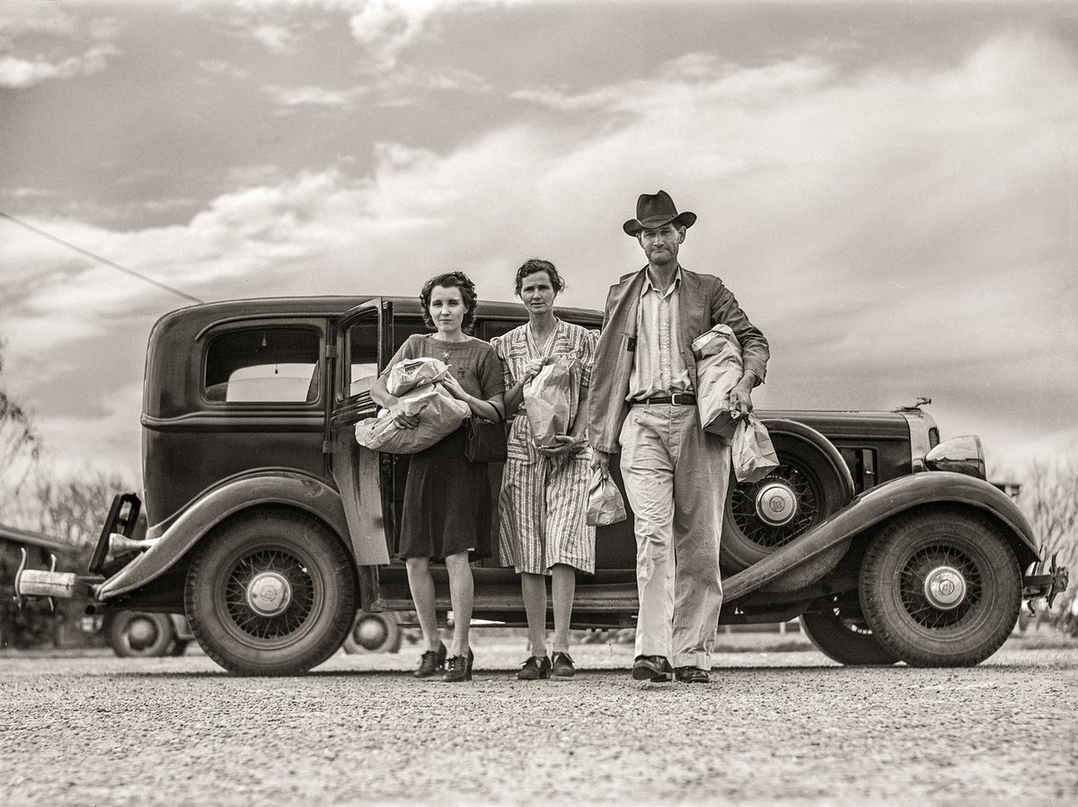 TracesofTexas's tweet photo. Weslaco, Texas, 1942. Farm Security Administration camp (Mercer G. Evans farm  workers' community). The Drake family returns from Saturday shopping. Nathan Drake, a well-known fiddle player, is on the right. Taken by Arthur Rothstein. Fantastic composition here! https://t.co/48IwkABsK3