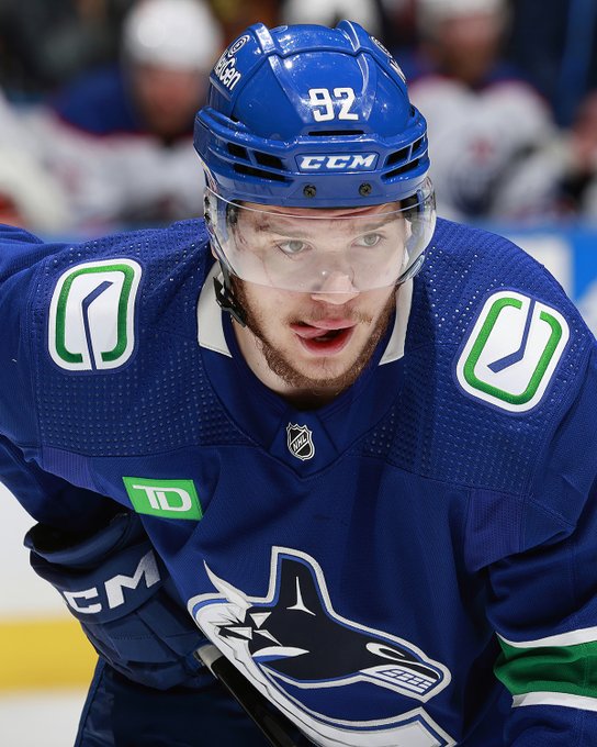 Vasily Podkolzin lines up for a faceoff in a blue Vancouver Canucks jersey
