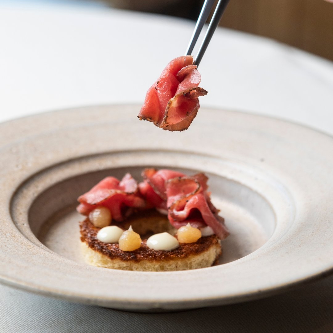 SepiaChicago's tweet photo. Pastrami-cured and smoked beef carpaccio with spring onion and smoked onion tallow, nestled upon brioche and finished with burnt onion consommé.

An ode to onion, meticulously layered in every bite. https://t.co/HSgbskCzTa