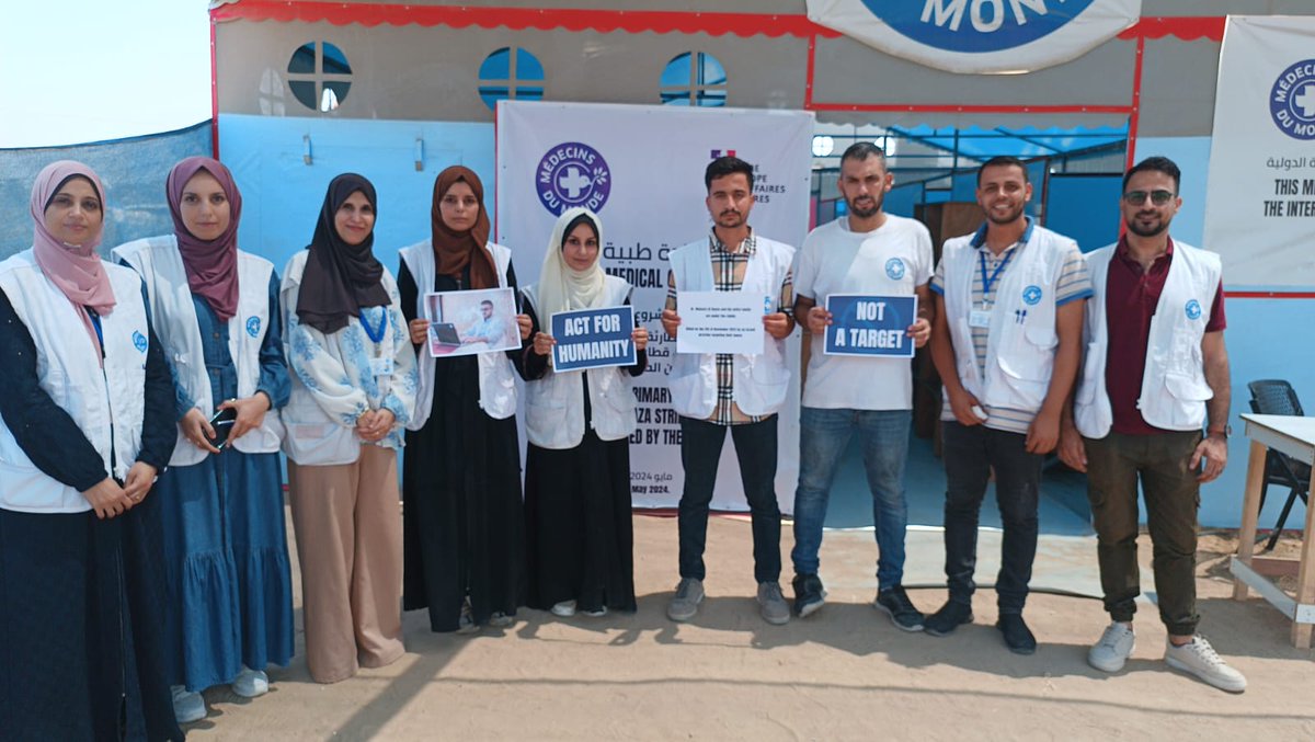 MdM_France's tweet photo. #WorldHumanitarianDay : 
Nos équipes en #Palestine mobilisées.

Dans leurs mains, la photo de notre collègue Maysara Rayyes tué avec sa famille dans les bombardements israéliens.

Les humanitaires ne sont pas des cibles.
Les civils ne sont pas des cibles.

#NotATarget https://t.co/BfXaVcNpVv