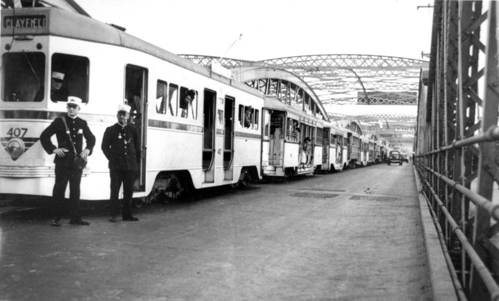Only_Paths's tweet photo. Tram derailment causes a traffic jam on the old Victoria Bridge this week in 1940. Possibly a rare sight at the time (?) but now a common sight with blue, white and yellow buses similarly stacked. We hope Metro will improve this situation.🤔 Pics: SLQ, Harrison Saragossi https://t.co/9qoorBtTt8