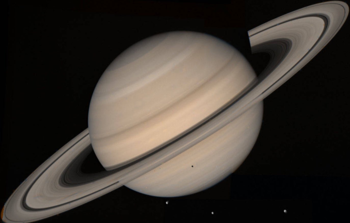 An image of Saturn taken by Voyager 2 as it passed by the planet in November 1980. Its magnificent, show-stopping rings stretch out around the planet while several of its moons are visible and dancing around the planet's lower perimeter.