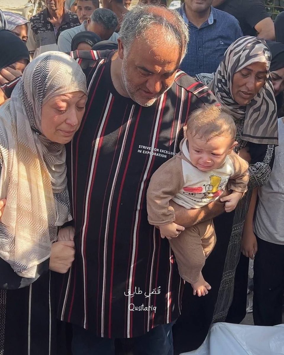 QudsNen's tweet photo. Heartbreaking scenes from Khan Younis, Gaza: A grieving infant bids farewell to his father, who was killed in the recent Israeli airstrikes. https://t.co/wz9BpaQjfO