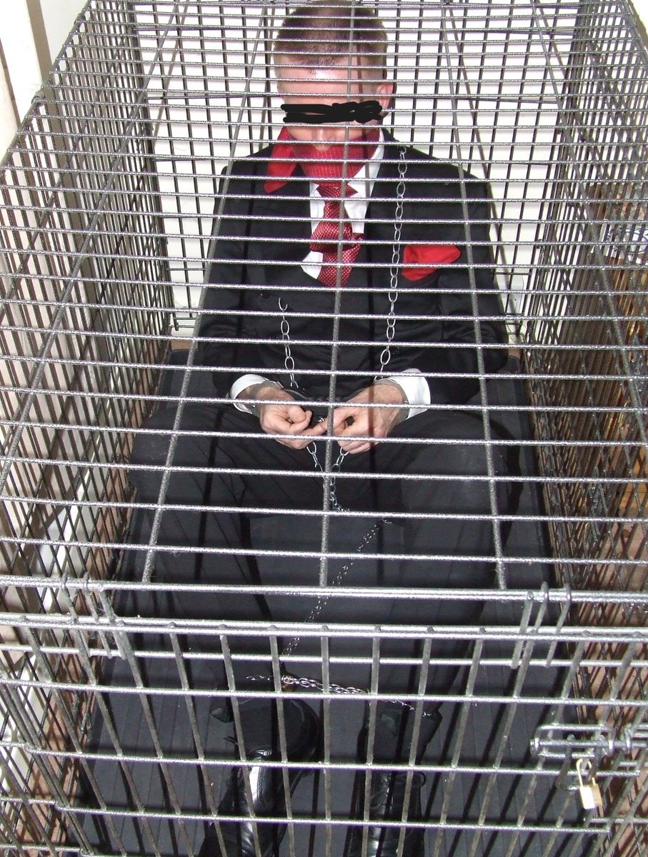 Cage door secure, the dom looked down on me judgmentally: 'Dan Wales, you're locked into your #suitandtie by your #handcuffs &amp; chains, you're caged like an animal &amp; when I leave this room you'll be locked in. You're aware I've previously imprisoned other suits for up to 24 hours'