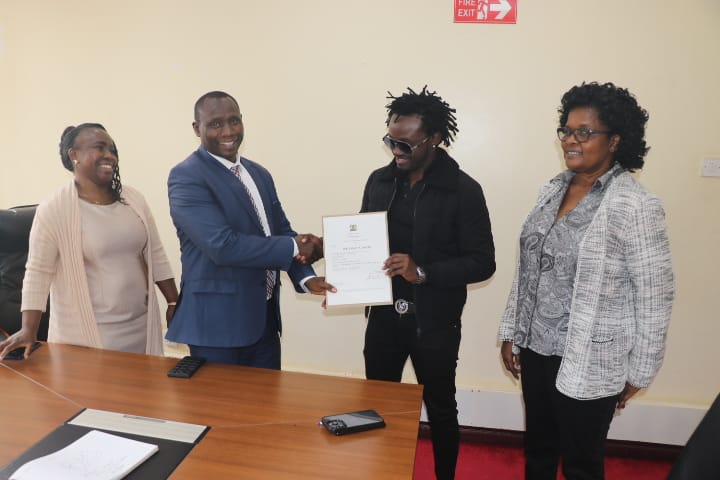 1/ Stephen Ngeno, KIPI Deputy Managing Director -Technical Services, flanked by Janet Kisio (R), Ag. Deputy MD, Corporate Services, &amp; Diana Mambiri of Trade Mark Division, presents a trade mark certificate to musician Kevin Mbuvi Kioko, popularly known as Bahati, at KIPI Centre.