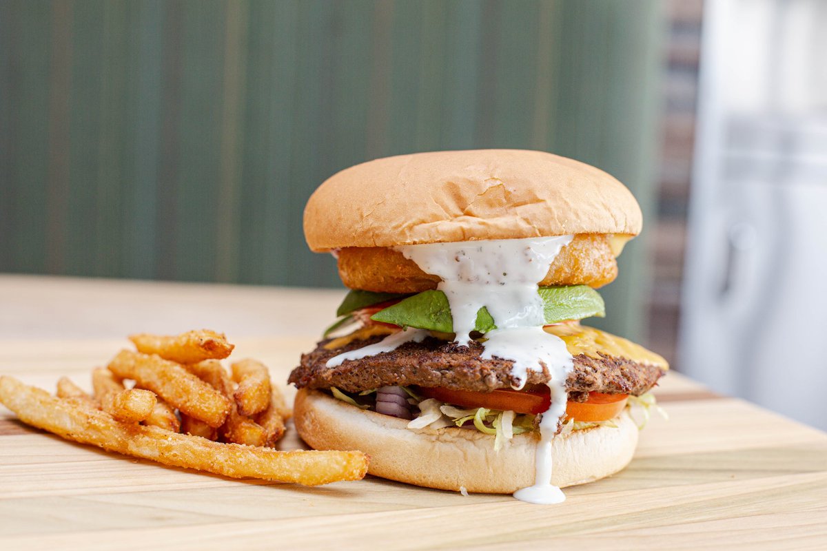 Stacked to perfection! 🍔🥑Dive into layers of flavor with every bite of this beauty, complete with crispy onion rings and a drizzle of creamy ranch. Who’s ready for a burger fix? 🤤 #burgercraving #oliveburger #halalfood #burger #onionrings #fries 
#eatoliveburger