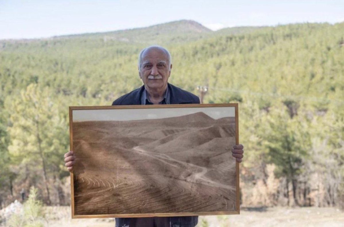 sciencegirl's tweet photo. Man posing with picture of forest he restored https://t.co/elWzRI54Xn