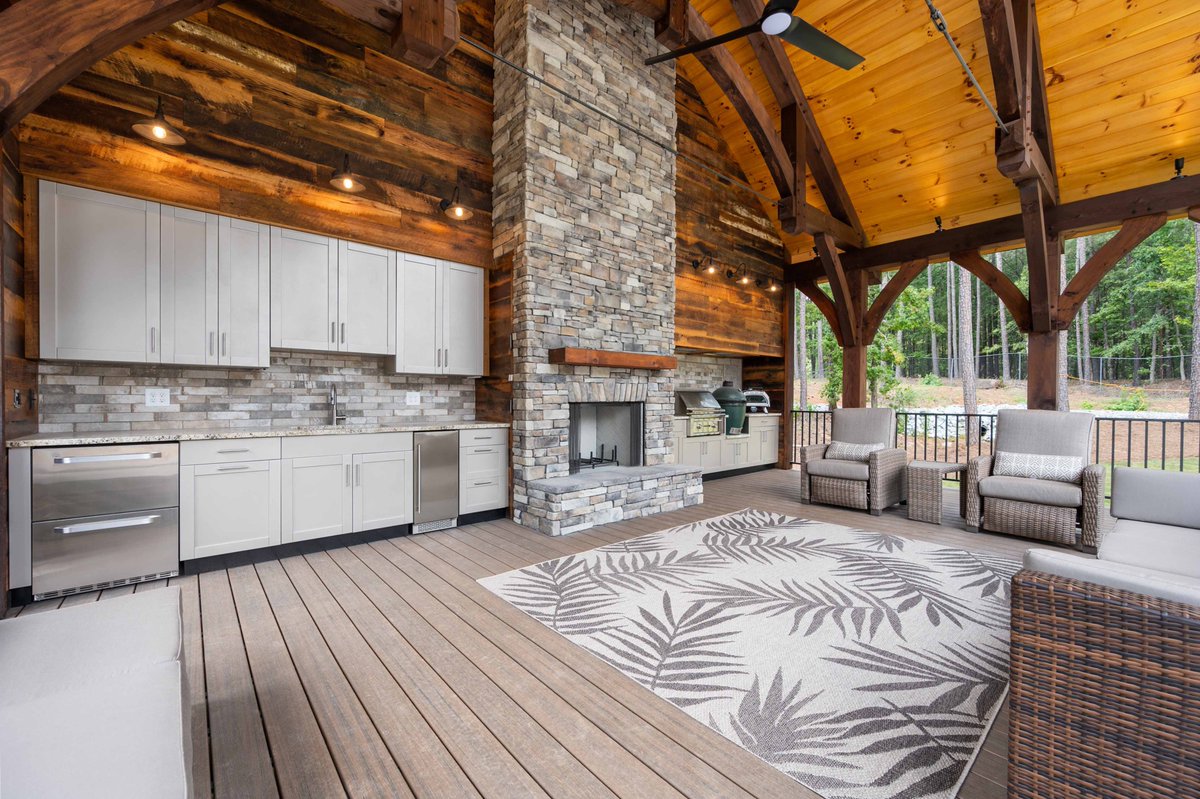 This spacious outdoor living space features our Key West door style in “Champagne 304” powder coat, while showcasing natural materials like wood and brick. Choose Danver for a superior quality fit and finish every time. danver.com/contact-us/