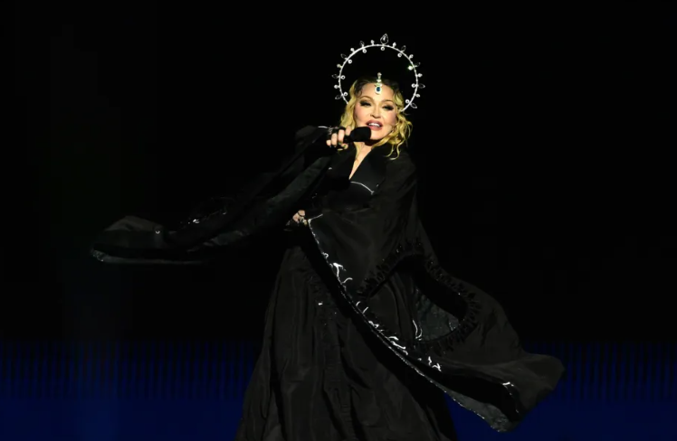 LovingGuiM's tweet photo. Madonna Celebrates Her Birthday With ‘Perfect’ Family Trip to the Vatican

Madonna recently shared glimpses of her family's visit to Vatican City on Instagram, following her 66th birthday celebrations. She posted photos in a stylish floral dress against the backdrop of Vatican City's ancient architecture and adorned walls featuring marble statues and religious paintings. Accompanying her were her 11-year-old twins, Estere and Stella, dressed in matching polka-dot outfits, and she also posed with rumored boyfriend Akeem Morris, cooling herself with a fan while he sported a white scarf. This post marks a continuation of Madonna's eventful year, including her recovery from a severe illness last year and her recent appearance at the Deadpool & Wolverine premiere, celebrating her iconic song "Like a Prayer" being featured in the film.