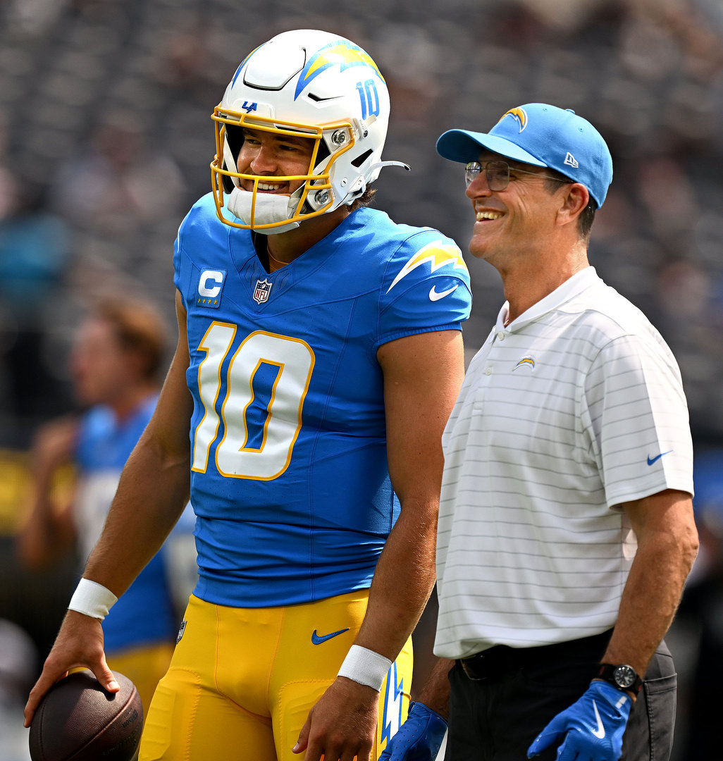 Chargers starting quarterback Justin Herbert converses with new head coach Jim Harbaugh during pregame warmups prior to playing the visiting Las Vegas Raiders at SoFi Stadium in Inglewood on Sunday, Sep. 8, 2024.  #chargers #nfl