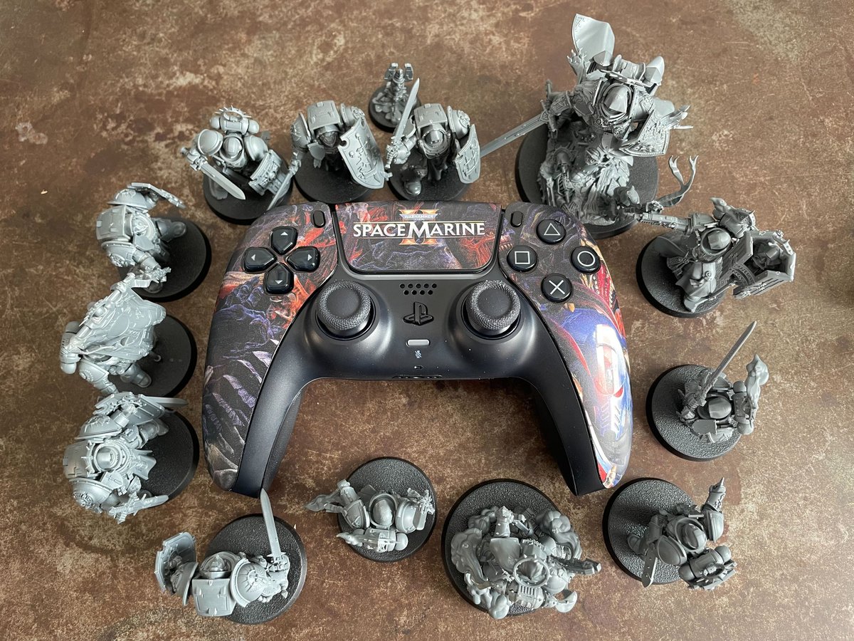 TechRaptor's tweet photo. Look what just blasted in via homing beacon! And it comes painted! Thanks to GW for sending us this Space Marine 2 PS5 controller, one less Space Marine item on our gray plastic pile of shame! #SpaceMarine2 #WarhammerCommunity #WarhammerMerchStore https://t.co/gzYFRr9bgh