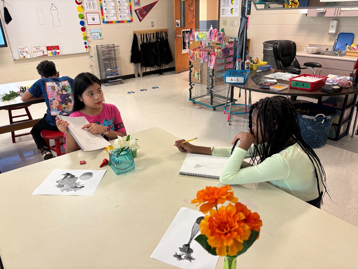 Still life art in 5th grade led to beautifully crafted scenes with real objects, prompt feedback from Mrs Price, and encouraging conversations between peers about their pieces.