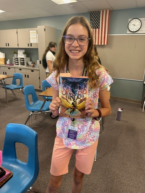 PollyHolyoke's tweet photo. So fun when librarians and teachers send me pics of new SKYRIDERS fans. My story about brave young couriers on their talking flying horses is now her favorite book! #flysafeflyfree #mgfantasy #librarians @PenguinClass #mglit https://t.co/IeEksVKjbP