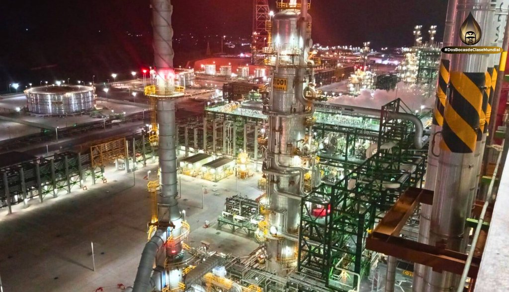 La producción de petrolíferos en la refinería Olmeca en Dos Bocas continúa día a día. En esta imagen nocturna se observa una parte de la Planta Coquizadora en la que se encuentran los hornos y la columna fraccionadora de esta planta. Al fondo a la izquierda se observan los