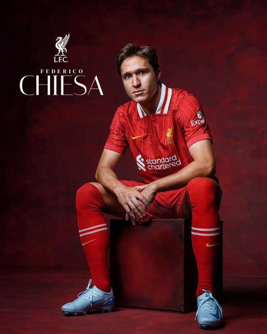 An image of Federico Chiesa sat down posing for a photo as he signs for Reds