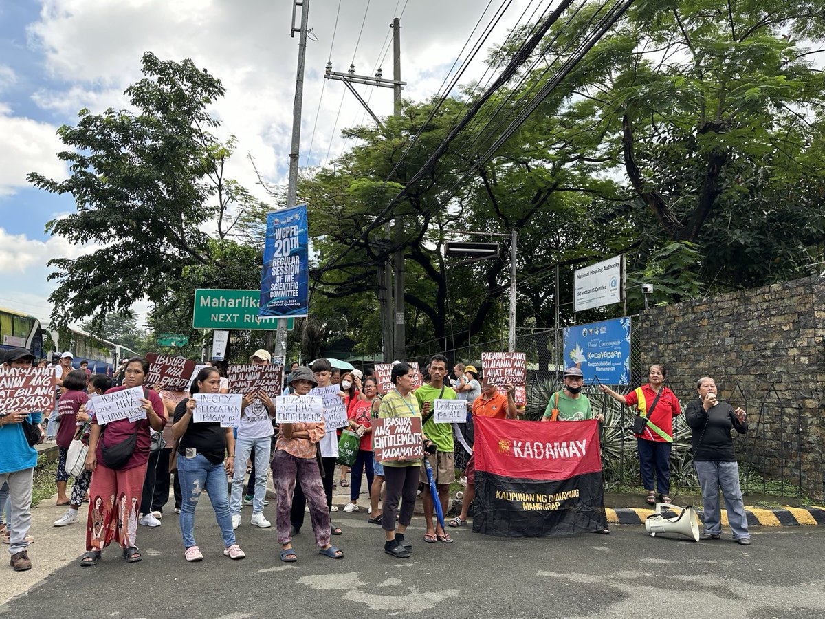 kadamayph's tweet photo. TINGNAN: Nagsagawa ng kilos-protesta ang Kadamay San Roque sa National Housing Authority upang kundenahin ang malawakang disqualification ng mga residente para sa programang pabahay ng ahensya. Ang mga entitlements na inilatag sa PIAC ay nagdudulot ng diskriminasyon. https://t.co/o3DqnJJWMd