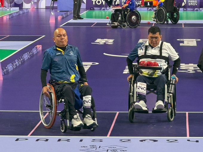 En la foto están Euclides y Edilson, izquierda y derecha respectivamente.  Ambos llevan ropa deportiva y guantes. Euclides usa camiseta blanca y pantalón azul oscuro y Edilson camiseta y pantalón azul.