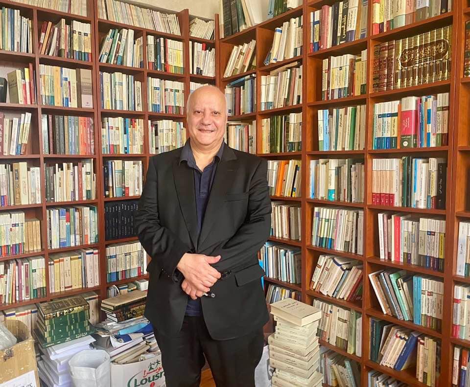 "أول التكوين"
عبد الإله بلقزيز مبتهجاً كما لو أن مكتبته تحاول أن تقرأه!