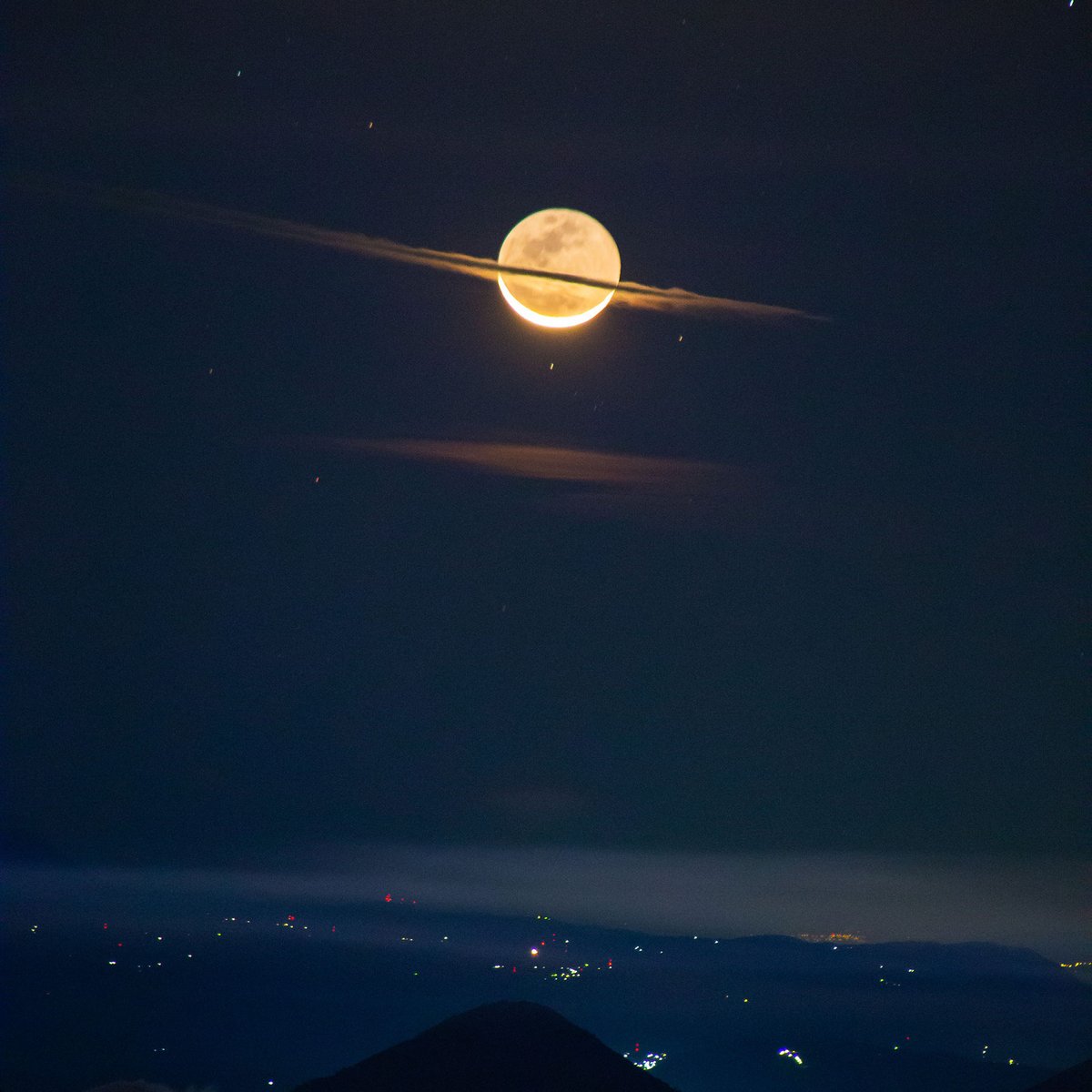 The Moon haloed with cloud, lit by the rising Sun, glowing above the dimly lit silhouette of active volcano Pacaya and the Guatemalan highlands. 
photo: Francisco Sojuel