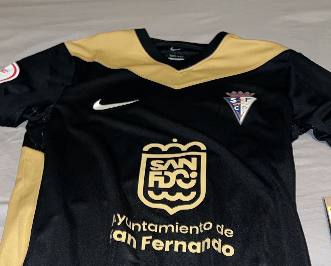 <a href="/SanFernando_CD/">San Fernando CD</a> @angel13cr Porque la camiseta lleva el escudo a color y en la que se juega los partidos se lleva en blanco. Es un error o se ha corregido para a color siempre?