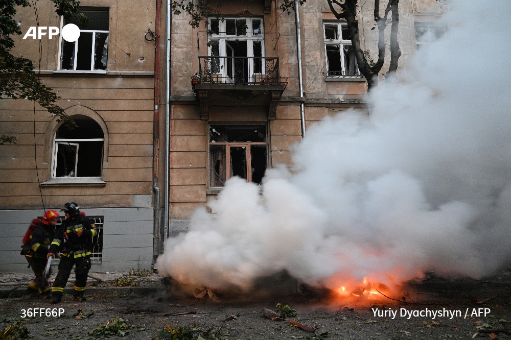 Rescuers work to extinguish a fire in a car following a missile attack on the western Ukrainian city of Lviv on September 4, 2024. 
