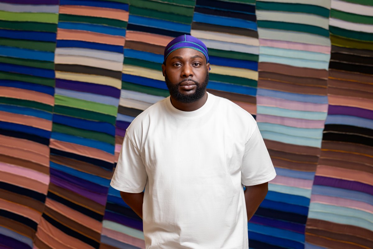 Anthony Olubunmi Akinbola is a first-generation American of Nigerian descent, raised in both the U.S. and Nigeria. Here, he stands in front of ‘Sunday’s Best’, one of three new works presented on the occasion of his #SCADMOA solo exhibition entitled “Good Hair.”