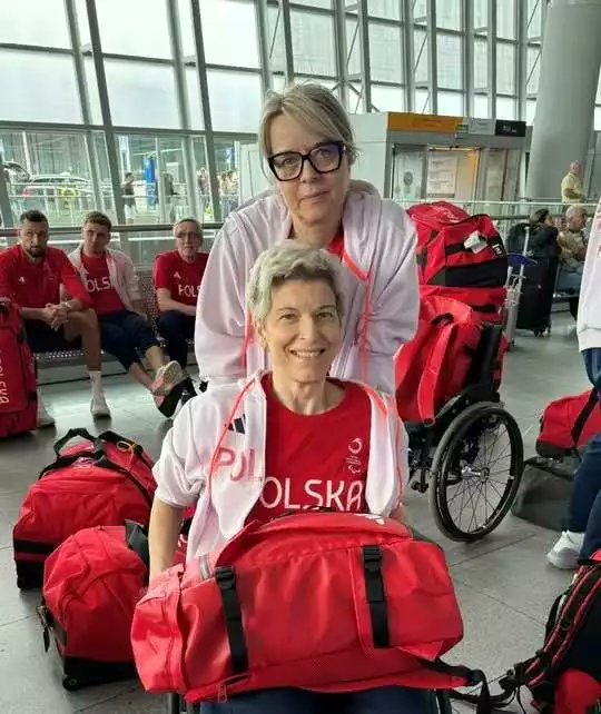 Polsport's tweet photo. Jestem wdzięczny igrzyskom paralimpijskim że mogę poznawać takie historie jak Doroty Bucław (zdobyła dziś brąz w tenisie stołowym – Natalia Partyka przyznała, że ten medal cieszy ją najbardziej ze wszystkich) i jej przyjaciółki i opiekunki Doroty Kubickiej. To opowieść o wielkiej tragedii ale też niezwykłej przyjaźni, poświęceniu i samozaparciu.
– Ten medal był wielkim marzeniem. Cieszę się, że wróciłam do sportu po wypadku. Może mój przykład podziała na innych, że warto walczyć o siebie i marzenia mimo najgorszych przeciwności – mówi ta pierwsza.
Poznałem je na igrzyskach w Rio. Napisałem wtedy reportaż, którego fragmenty tu wkleję:
Są nierozłączne od 25 lat. Od wypadku samochodowego, w którym obie uczestniczyły. Dorota Kubicka prowadziła, Dorota Bucław była pasażerką. Maluch podskoczył na przejeździe kolejowym i pasażerka poczuła chrupnięcie w szyi. To pękł kręgosłup na odcinku szyjnym. Przez cztery miesiące była w stanie ruszać wyłącznie oczami.
Gdy wyszła ze szpitala, Dorota Kubicka zabrała ją do swojego mieszkania w Solcu Kujawskim, które przebudowała na potrzeby niepełnosprawnej przyjaciółki.
Od tej pory są nierozłączne. Dorota towarzyszy Dorocie w większości codziennych czynności życiowych i we wszystkich startach. – Poznałyśmy się w 1994 roku, a jakże, w szpitalu. Ja byłam pacjentką, Dorota moją rehabilitantką – opowiada Dorota Bucław. - W 1994 roku gdy miałam 17-lat, podczas gdy w koszykówkę kolega wpadł na mnie tak nieszczęśliwie, że przycisnął ciałem moją rękę do ściany. A ja zamiast wyszarpnąć rękę, pociągnęłam szyją i zerwałam połączenia nerwowe. Prawa ręka była bezwładna.
Po rehabilitacji pierwsza Dorota postanowiła wrócić do sportu. Wybrała tenis stołowy. Najpierw musiała przestawić się na leworęczność.
– Uczyłam się pisać od nowa. Przepisywałam całe książki, żeby wyćwiczyć rękę. Na szczęście rodzice w niczym mnie nie wyręczali, dzięki temu błyskawicznie nauczyłam się wiązać sznurówki, ubierać i wszystkich pozostałych czynności – opowiada Dorota Bucław.
Zaczęła robić błyskawiczną karierę w tenisie. Zdobyła mistrzostwo Polski, w 1997 zakwalifikowała się do reprezentacji Polski, a dwa lata później dostała powołanie na igrzyska paraolimpijskie w Sydney. Miała startować w deblu z 11-letnią Natalią Partyką.
Ale do Sydney nie poleciała. 6 grudnia 1999 zdarzył się drugi wypadek.
– Przyjechałam do Bydgoszczy odwiedzić ukochaną babcię, która była w kiepskim stanie. Spotkałam Dorotę, która akurat kupiła mieszkanie w Solcu Kujawskim. Namówiła mnie, że mi je pokaże. Wsiadłyśmy w malucha. Pojechałyśmy. Pierwszy i jedyny raz weszłam wtedy sama na to drugie piętro. Wypiłyśmy herbatę. Wracając przejeżdżałyśmy przez tory... – opowiada Dorota Bucław.
Obie mówią, że wcale nie jechały szybko. Wręcz zwolniły w feralnym miejscu, bo tory są tam nierówne. Nawet rowerzyści zsiadali tam z rowerów. – Jestem wysoka, uderzyłam głową w podsufitkę. Nie miałam do niej daleko. Wiadomo jakie pasy są w maluchu. I stało się. Poczułam tylko prąd i ogarnęła mnie ciemność. Obudziłam się dopiero w szpitalu – Dorota Bucław.
– Mój szok był tak głęboki, że okres kilku miesięcy po wypadku wymazałam z pamięci. Mam lukę. Pamiętam tylko, że w drodze do szpitala powtarzałam w kółko: „Panie Boże, spraw, żeby Dorota przeżyła! Jeśli przeżyje, zrobię wszystko, żeby jej pomóc!”. Przeżyła, ale poza głową była całkowicie unieruchomiona. Na początku zaczęłam pomagać z powodu wyrzutów sumienia. Wiedziałam, że przecież celowo tego nie zrobiłam, ale czułam się odpowiedzialna – opowiada Dorota Kubicka.
– To było poświęcenie totalne. Dorota nastawiała alarm co dwie godziny, nawet w nocy, budziła mnie i ćwiczyłyśmy. Sama straciła przy tym kupę zdrowia. Wiem, że dzięki niej bardzo szybko osiągnęłam możliwe najlepszą sprawność jak na mój przypadek – mówi Dorota Bucław.
Po wyjściu ze szpitala Dorota zabrała Dorotę do swego mieszkania w Solcu Kujawskim, tego które zwiedzały feralnego dnia. Przyjaciółka potrzebowała stałej opieki. Do dziś ma poważne problemy z oddychaniem. Często trzeba podawać jej tlen.
Dorota Kubicka przebudowała mieszkanie, ponieważ było niefunkcjonalne, miało np. zbyt wąskie futryny. Zamontowała też podnośnik do kąpieli.
Na 2. piętrze bez windy Dorota Bucław utknęła na parę lat. Sąsiedzi, których dziewczyny nie mogą się nachwalić, służyli pomocą przy zniesieniu wózka – a potrzeba było do tego dwóch silnych mężczyzn. Nie chciały jednak nadużywać życzliwości i korzystały z niej tylko w wyjątkowych wypadkach. Sytuacja zmieniła się gdy po siedmiu latach Fundacja Dum Spiro Spero ufundowała specjalny schodołaz na gąsienicach, który zwozi Dorotę. Bez niego nie miałaby szans na treningi.
– Dorota ma w sobie ogromny upór i konsekwencję. Po wypadku ja bym najchętniej wszystko za nią zrobiła, umyła, ubrała, nakarmiła. Kiedy na początku leżała, brzydko mówiąc, jak beton, we wszystkim ją wyręczałam. Chciałam nadal, ale później już mi nie pozwalała. Prowadziłyśmy o to w domu prawdziwe wojny. Była zbyt ambitna. Pół kubka jogurtu jadła przez pół godziny, ale się nie podawała. Dzięki tej samej determinacji znów zaczęła odnosić sukcesy w sporcie. Pojechała aż na dwa igrzyska. Gdyby mi uległa, pewnie leżałaby w łóżku jak kłoda, a ja nie byłabym w stanie funkcjonować – mówi Dorota Kubicka.
– Jeżdżę z nią na każde zawody, wykorzystując urlop w szpitalu, gdzie jestem rehabilitantką. A jak już go nie mam, to urlop bezpłatny. To moja prywatna sprawa, nie chcę słać pism i brać nikogo na litość. Ale trochę bywać w pracy muszę, bo to nasze podstawowe źródło utrzymania. Dorota jest przez to poszkodowana i czasem omijają ją zgrupowania. Wówczas trener Madejska wyznacza jej zadania przez Skype’a i Dorota trenuje z zaprzyjaźnionym Danielem Szczepańskim – opowiada Dorota Kubicka.
Gdy pytam o jej zadania, rozkłada ręce: wszystko czego Dorota potrzebuje. Musi być zawsze gotowa. Od ubrania przyjaciółki, po pomoc w toalecie, bo Dorota sama nie przesadzi się z wózka. Po pomoc na treningu przy podawaniu piłeczek. W karcie zawodniczej ma wpisane, że podczas meczów wolno jej być przy bandzie, choć zazwyczaj mają do tego prawo tylko trenerzy. Jeśli Dorota będzie miała problem z oddychaniem, poda jej tlen. Jeśli chwyci skurcz mięśni, rozluźni masażem lub zrobi zastrzyk.
Paryż to czwarte igrzyska paralimpijskie Doroty Bucław. Nigdy nie zdobyła medalu, bo w przeciwieństwie do mistrzostw Europy czy świata (z obu imprez ma 4 medale), bowiem sklasyfikowana w najniższej kategorii (WS1) Dorota startuje z zawodniczkami o wiele sprawniejszymi z kat. WS2.
A jednak zaszła aż do półfinału a w nim była bliska sensacyjnego zwycięstwa z nr 1 w światowego rankingu, Włoszką Giadą Rossii, mistrzynią świata i Europy. Skończyło się minimalną porażką 2-3.
– To był znakomity występ Doroty. Aż włoski trener podszedł do nas, żeby jej pogratulować gry i ducha walki. Jeszcze nie widział tak świetnie grającej Polki – mówił trener kadry, Marek Biernat. - Funkcje sprawnościowe i możliwości ruchowe Włoszki zdecydowaniem większe od tych jakie mam Dorota. Ma o wiele sprawniejsze ręce. Łatwiej jej było rozrzucać piłki forehandem i backhandem, a jednak dałam radę jej się postawić – tłumaczył.
- Sama siebie zaskoczyłam. Chciałam po prostu wyjść na mecz i wypaść jak najlepiej. Może nawet udało by się wygrać, ale prowadząc w drugim secie za bardzo wychyliłam się gdy zaserwowała krótki serwis i przydzwoniłam żebrami w kant stołu. Bolą mnie do teraz. To powtórka z igrzysk w Rio. Tam przydarzyło mi się to samo i to z tą samą rywalką - opowiadała Dorota.
- Medal Doroty cieszy mnie najbardziej ze wszystkich. Jest jedynką i wiecznie odbijała się od podium na igrzyskach przez to, że jej kategoria jest łączona z silniejszą. Poza tym znamy się tyle lat. Należał jej się ten medal – mówi 12-krotna medalistka paralimpijska w tenisie stołowym, Natalia Partyka.
Za cztery lata na igrzyskach w Los Angeles 2028 najprawdopodobniej będzie już mogła startować w swojej własnej kategorii. Międzynarodowa Federacji Tenisa Stołowego chce wystąpić do Komitetu Paraolimpijskiego o rozdzielenie obecnej klasę na dwie. Uznano, że dysproporcja ruchowo mięśniowa między zawodnikami obu klas jest obecnie zbyt duża.
- Jeśli tylko zdrowie pozwoli to na pewno będę o wyjazd do Los Angeles, bo tam będę miała szansę na medal jeszcze lepszego koloru. Skoro mam już dwa medale mistrzostw świata i dwa mistrzostw Europy, fajnie byłoby zakończyć karierę dwoma medalami z igrzysk paralimpijskich. Głód wygrywania wciąż we mnie jest. Nie czuję się jeszcze spełnionym sportowcem – deklarowała.
- Ten medal to ogromnie spełnienie. Cieszę się, że wróciłam do sportu po wypadku. Może mój przykład podziała na innych, że warto walczyć o siebie mimo najgorszych nieszczęść. Warto mieć marzenia i do nich dążyć, mimo największych przeciwności, jakich zwykłemu człowiekowi nawet ciężko sobie wyobrazić – mówi Dorota Bucław
