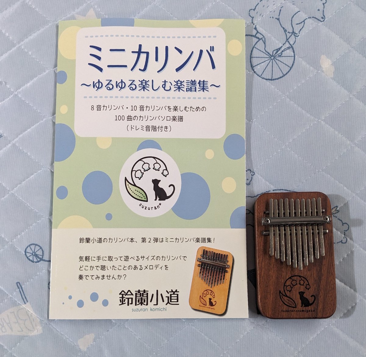 kalimba104's tweet photo. 鈴蘭小道さんの楽譜集が届いた💓
（写真のミニカリンバは今回のキットではなく、前回のコラボカリンバ）
オールカラーで紙も上質！しかも100曲掲載なんて凄すぎです
これがあれば一生カリンバを楽しめそう🎶
＃鈴蘭小道　＃ミニカリンバ
＃ゆるゆる楽しむ楽譜集 https://t.co/8sSeoMJjCt