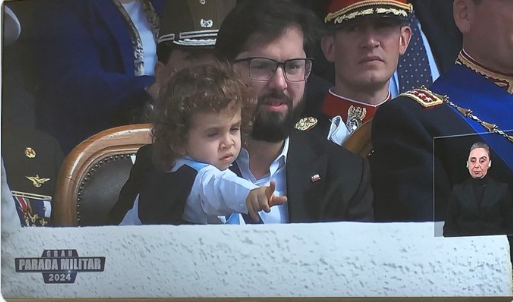 Iherreraa's tweet photo. Una simple pregunta.  Boric sabe lo que es el protocolo?.  Esta es una parada donde el presidente debe estar 100% dedicado a todos quienes desfilan en la Parada Militar y no estar jugando con un niño. https://t.co/IOKEiYU5Va