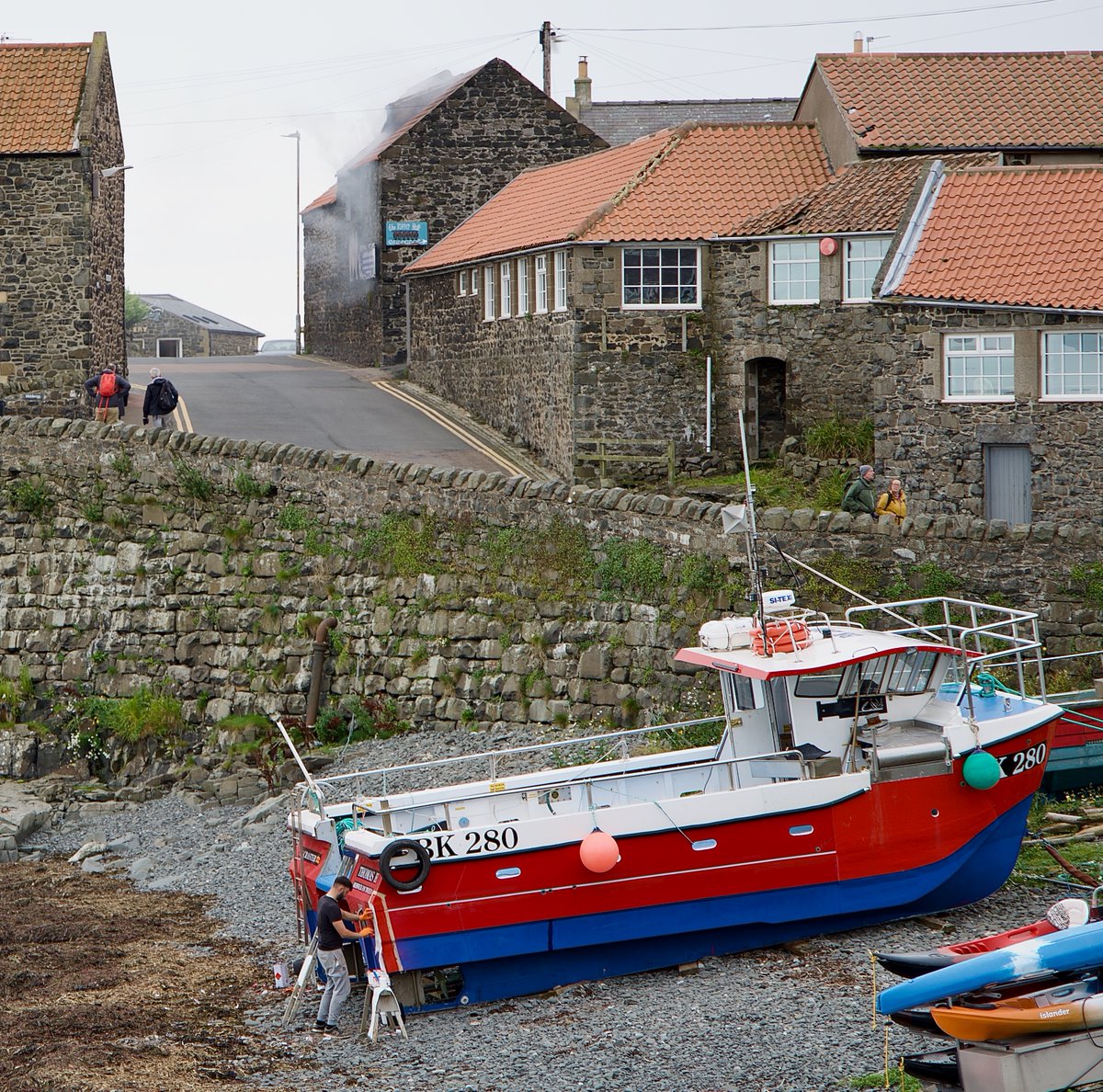 tweedtotyne's tweet photo. Craster is a tidy little port on the #Northumberland coast. Many scoot through on the way to Dunstanburgh but there's a lot more to see - the Chain Home Low radar station, the old Whinstone bins support, working boats getting a spruce up with the smokehouse going well behind. https://t.co/dnNkZgHQEN
