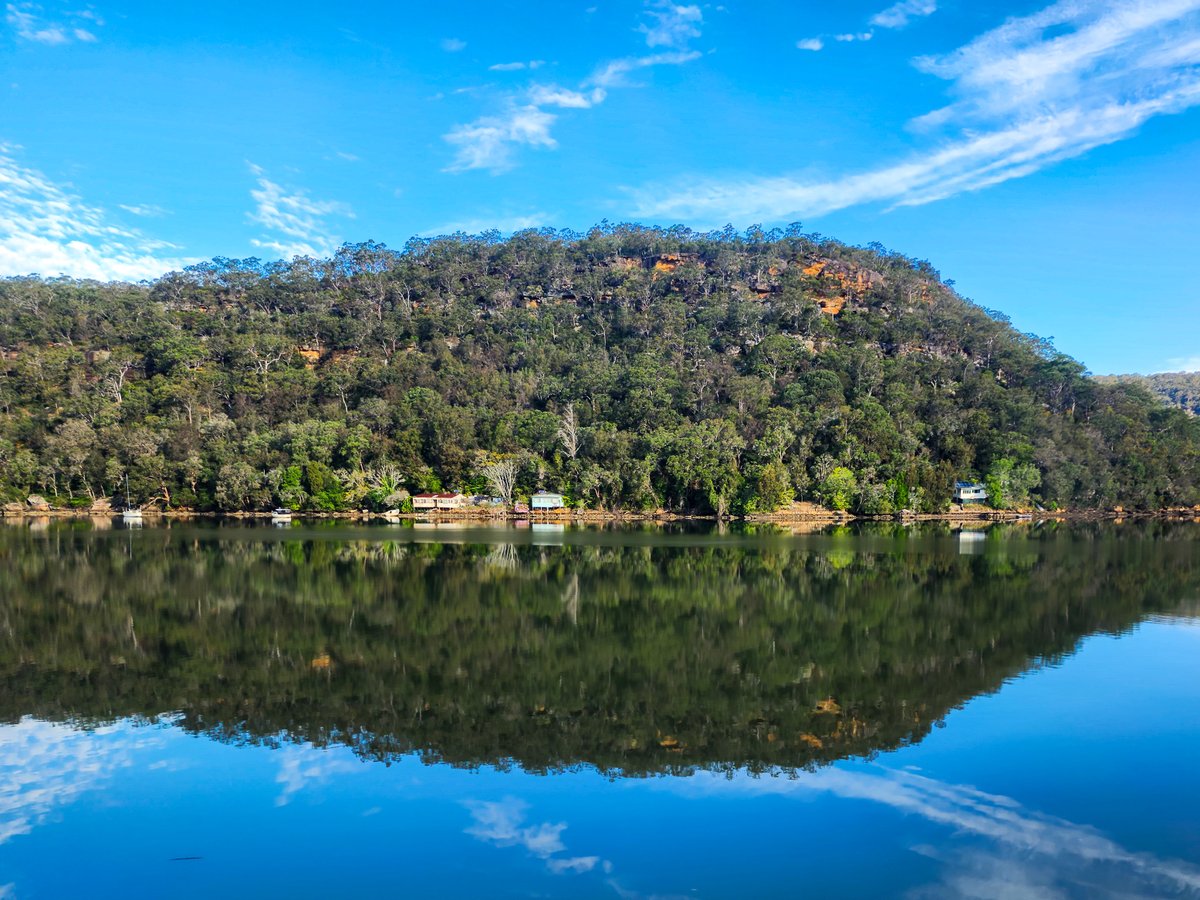 WONDABYNE, 65km from Central, is a famous, isolated station serving a collection of shacks in dense forest. It has two short platforms that only fit one train door. They have small shelters and a level crossing between. It's the only station in Australia with no road access (1/2)