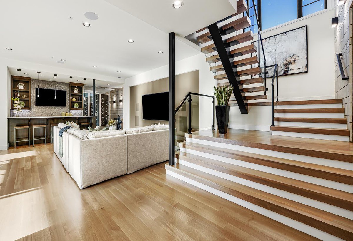 SDSmithHomes's tweet photo. Behold the grandeur of this staircase in all its glory! It effortlessly opens up the room and adds an opulent touch with the combination of stone accent wall, floating staircase, frameless glass railing, and solid rift cut white oak wood treads that match the hardwood floors. https://t.co/QpsGukLV7Q