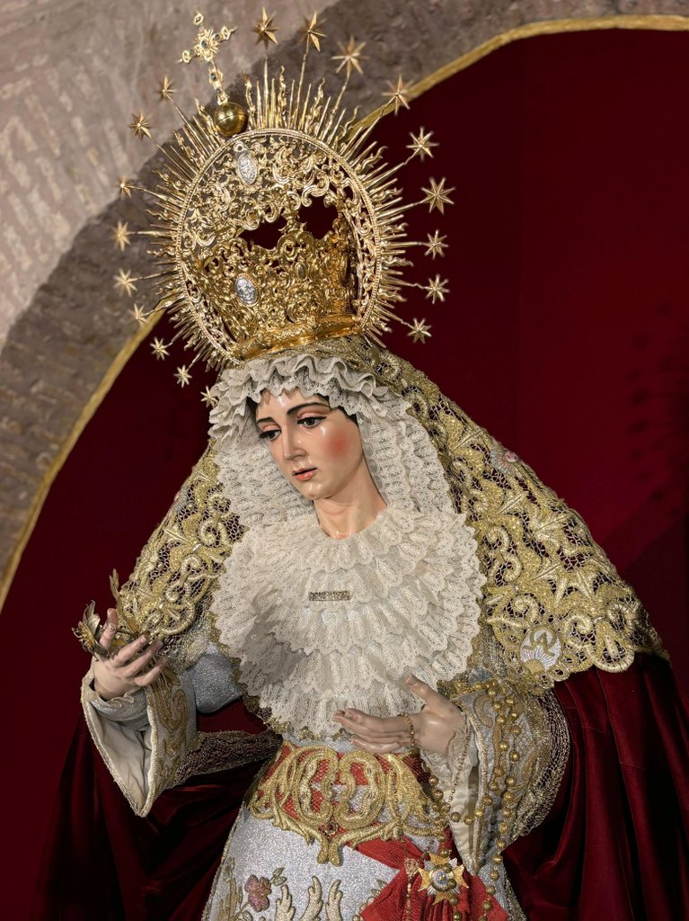 En la tarde de ayer tuvo lugar un nuevo cambio en la vestimenta de Nuestra Señora de la Aurora a cargo de su vestidor, D. José Manuel Lozano, y el grupo de camareros y camareras. Porta saya y toca de sobremanto bordadas en aplicación y manto de terciopelo de seda burdeos.