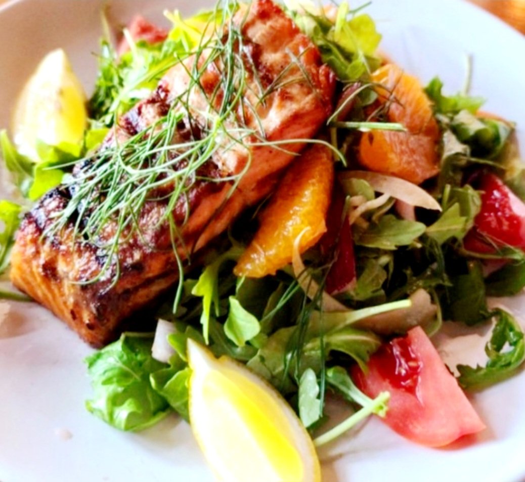 Our Grilled Salmon Milanese presents a culinary canvas where the perfectly grilled salmon shines as the masterpiece, adorned with a crown of vibrant greens, cherry tomatoes, and capers, each bite a brushstroke of flavors that celebrate both simplicity and sophistication.