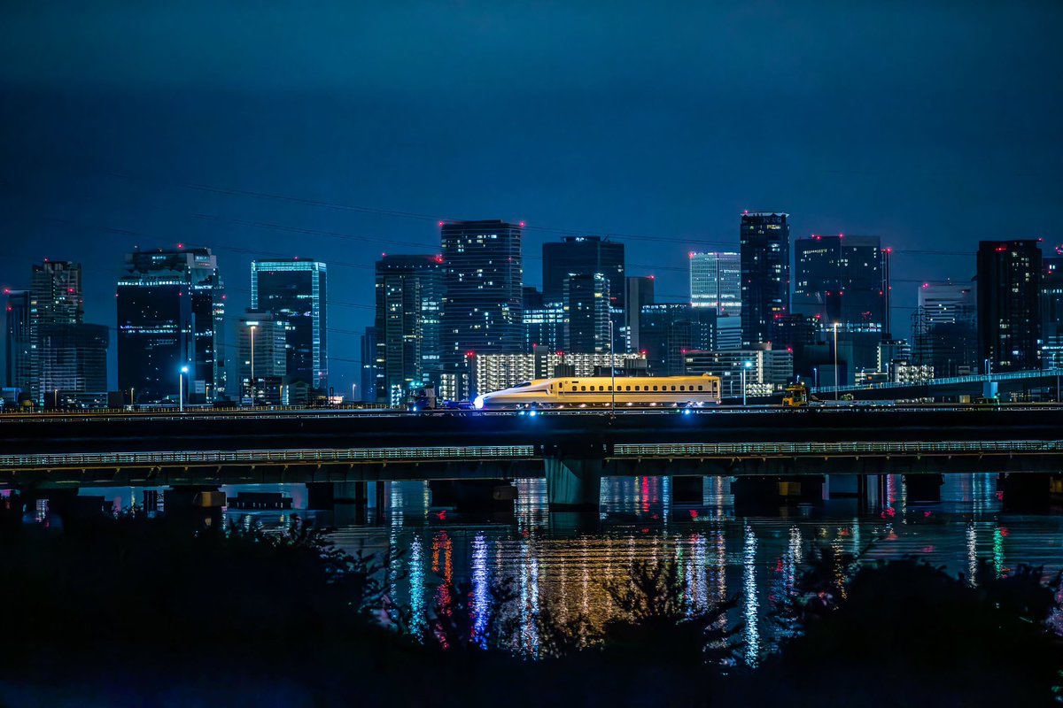 HarborLight1211's tweet photo. 淀川を渡るN700S J47編成の陸送。
もう少し早い時間ならビル群に灯りがもう少し多く点いていて煌びやかでしょうね。
都会の喧騒から離れて遠くのビル群を見つめながら陸送を待つ時間は、僅かながらノンビリと出来て優雅な時間に思えました。 https://t.co/ynOXuwSlTh
