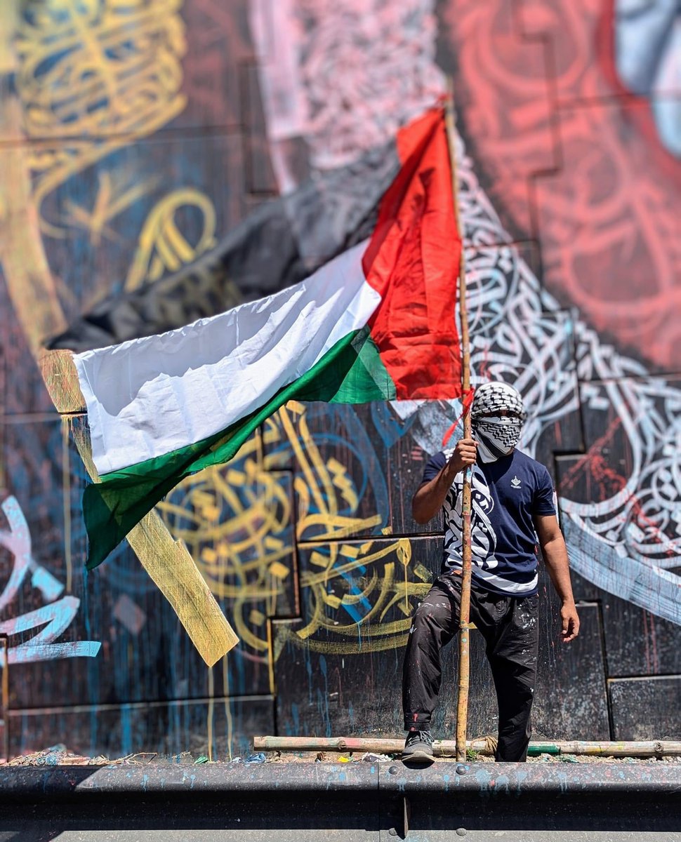ridoanmahbub's tweet photo. Bangladesh's largest graffiti artwork has transformed the walls of Kachpur in Narayanganj into a breathtaking urban canvas. This vibrant mural features intricate Arabic calligraphy framing a powerful central image of one hand helping another, symbolizing unity and support. This public art, set against the backdrop of daily life, has quickly become an iconic landmark, capturing the attention of both locals and visitors.