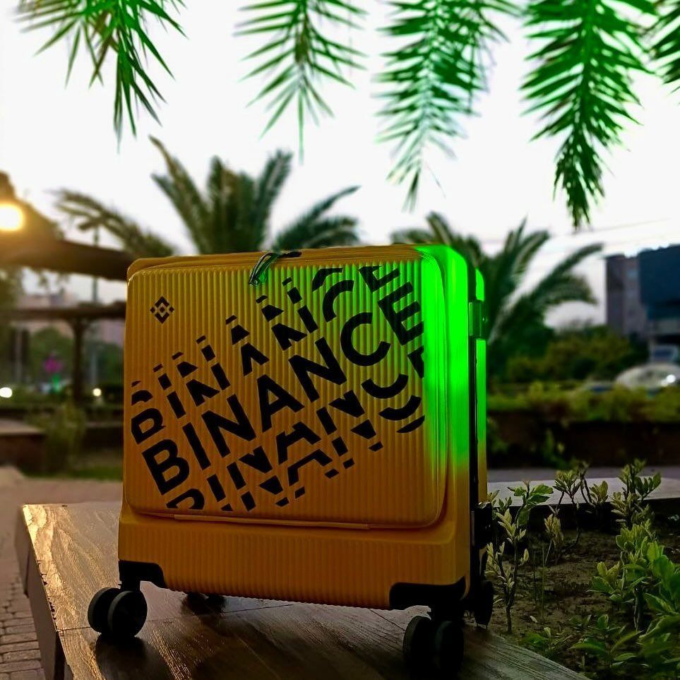 binance's tweet image. Binance suitcase glowing like it knows it’s the main character.