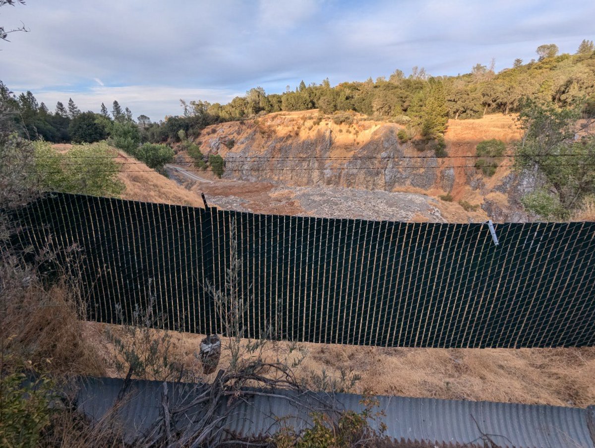 A "suspension fence"? 

This has to be the most unusual configuration of a chain link fence I've ever seen in my life
