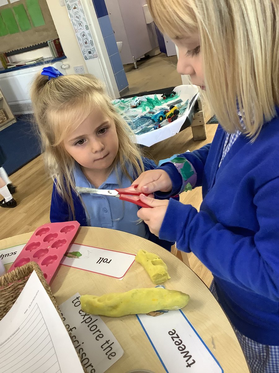 In the play-dough area nursery are practicing cutting with scissors ✂️